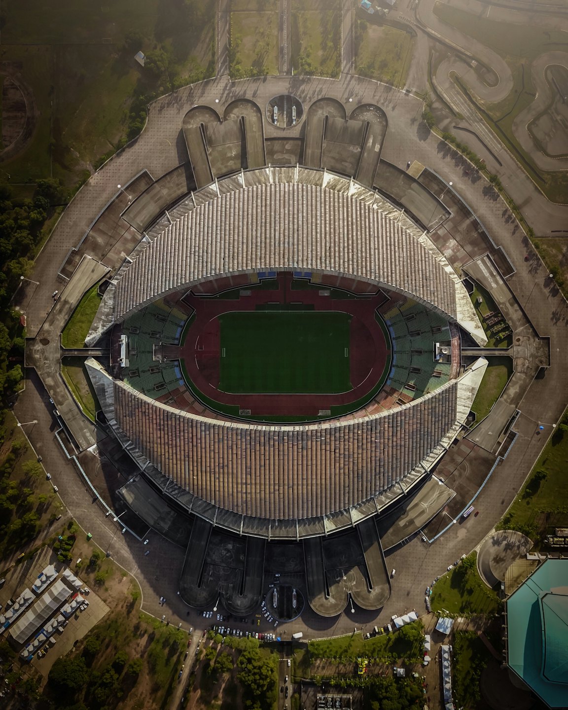 Un grande stadio sportivo con campo verde e pista rossa.